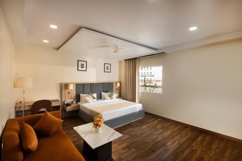 a hotel room with a bed and a couch at asar Capoors Hotel by Orion Hotels in Lucknow