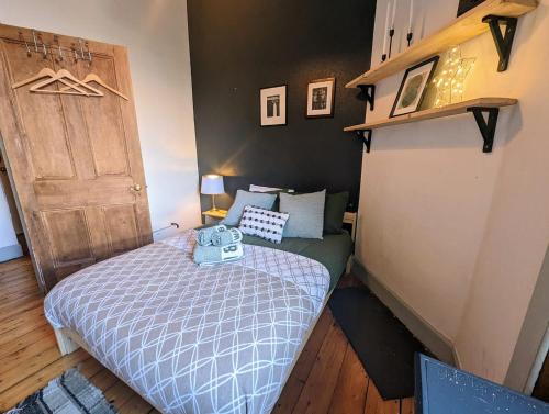 a small bedroom with a bed and a brown door at Cosy 1 bedroom flat close to city centre in Edinburgh