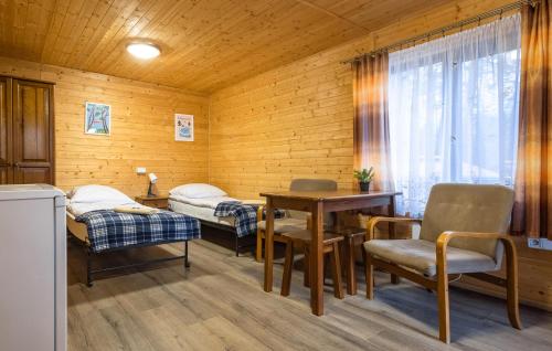 Nice Home In Ruciane - Nida في روسيان-نيدا: غرفة بسريرين وطاولة وكراسي