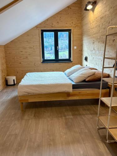 Chalet muguet & Jaccuzi privatif في Rochesson: غرفة نوم بها سرير في جدار خشبي