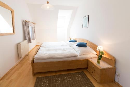 ein Schlafzimmer mit einem Bett mit einem Holzrahmen in der Unterkunft Bauernhof Zoller in Hartmannsdorf
