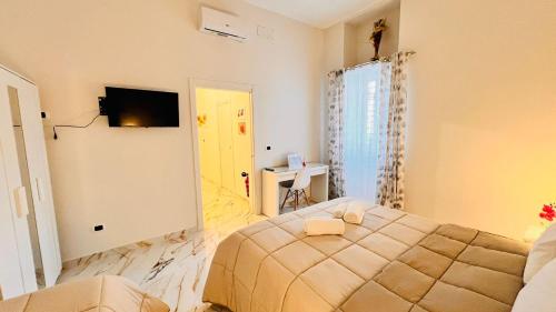 ein Schlafzimmer mit einem Bett und einem Fernseher darin in der Unterkunft torres family locazione turistica in Foggia