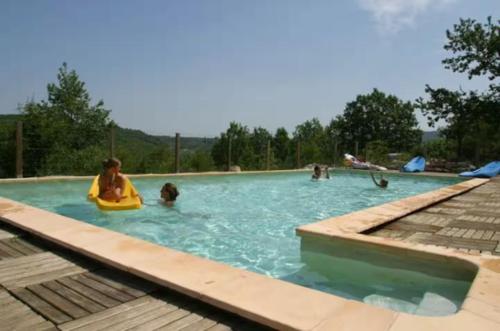 eine Gruppe von Menschen, die in einem Schwimmbecken spielen in der Unterkunft Les Gites De Chauzon 3 Avec Piscine in Chauzon