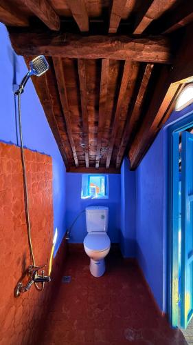 Un baño con inodoro en una habitación azul. en Dar Dadicilef, en Chefchaouen