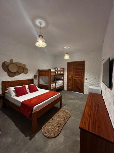 a bedroom with a bed with red pillows on it at Chalé Brisa do Pontal in Fortim