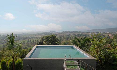 ein Swimmingpool mit Blick auf einen Berg in der Unterkunft Treebo Samsara Villas And Spa in Rāmnagar