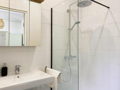 een witte badkamer met douche en wastafel bij Modern Apartment 2 in Historic Abbey in Bemelen