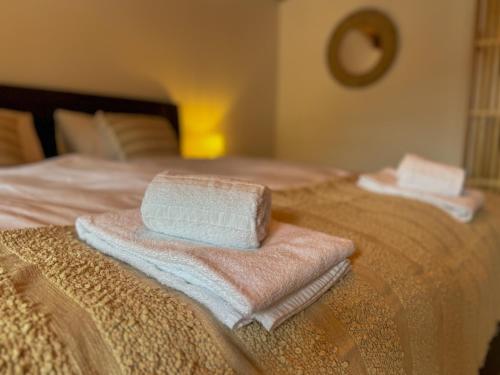 two towels are stacked on top of a bed at City Center Apartment 1 in Interlaken