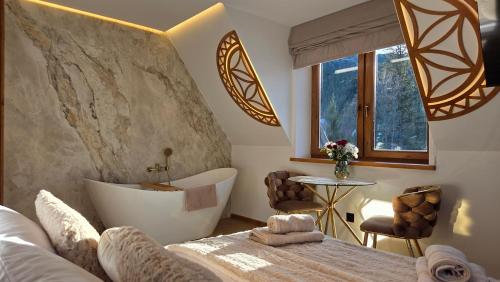 a bedroom with a tub and a bed and a table at Willa Zielone Wzgórze - Zakopane - Luksusowe apartamenty in Zakopane