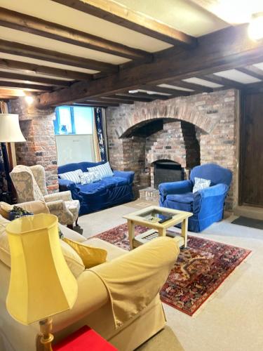 Una sala de estar con un sofá y una chimenea. en Garden flat at Broomfield, en Moffat