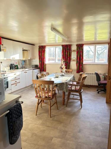 Una cocina con una mesa y sillas en una habitación. en Garden flat at Broomfield, en Moffat
