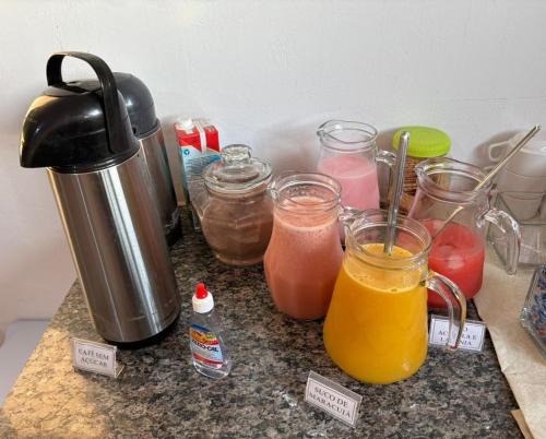 a counter top with jars of drinks and a blender at Aqui Hotel in Patos de Minas