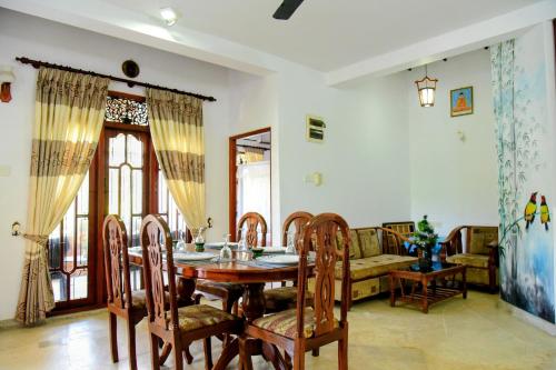 Un comedor con una mesa y sillas y un sofá. en Accoma Villa, en Hikkaduwa