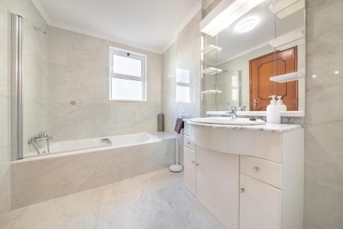 un bagno bianco con vasca e lavandino di Esmael Apartment By Mth a Funchal