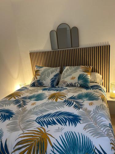 Appartement charmant au cœur de Saint-Rémy, idéal pour une escapade provençale ! في سان ريمي دو بروفنس: غرفة نوم بها سرير مع لحاف أزرق وأبيض