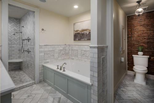 a bathroom with a bath tub and a toilet at The New Victorian Mansion Bed & Breakfast in Saint Paul