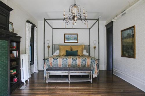 a bedroom with a bed and a chandelier at The New Victorian Mansion Bed & Breakfast in Saint Paul