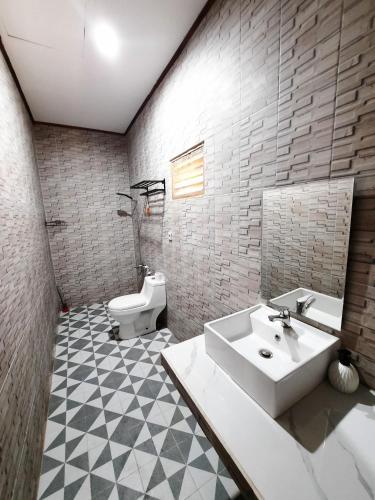 a bathroom with a sink and a toilet at Dua Bidadari Villa in Cikanteh