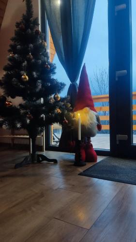 a christmas tree with a gnome next to a candle at Art A Cabin in Teşila