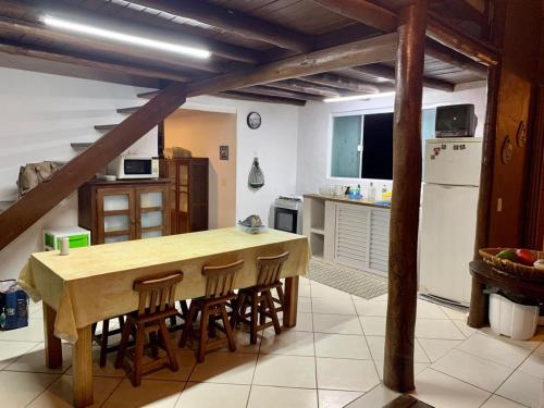 Chalé Suites Maresias في ساو سيباستياو: مطبخ مع طاولة وكراسي وثلاجة