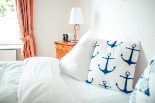 um quarto com uma cama com almofadas azuis e brancas em Strandhotel Strande em Strande