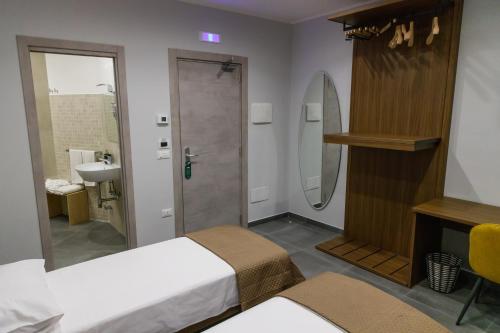 een badkamer met 2 bedden, een wastafel en een douche bij La Corte Park Hotel & Spa in Palma Campania
