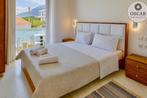 a bedroom with a bed with two towels on it at Oscar’s Apartments Drymades in Dhërmi