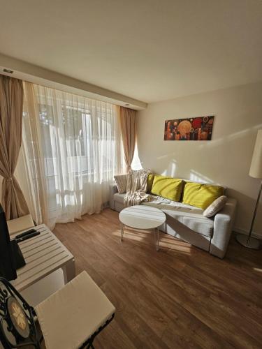 a living room with a couch and a table at Sunlit Forest Suite in Borovets