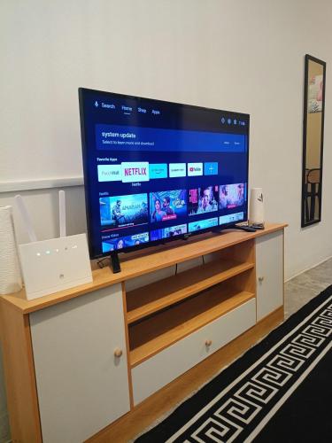 a flat screen tv sitting on top of a tv stand at Ipoh budget house in Ipoh