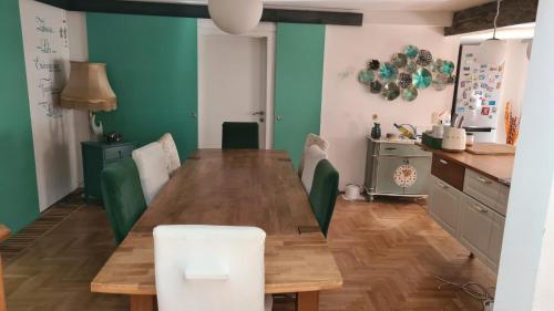 una sala da pranzo con tavolo in legno e sedie verdi di Spacious 4-Bedroom LOFT a Katzbach