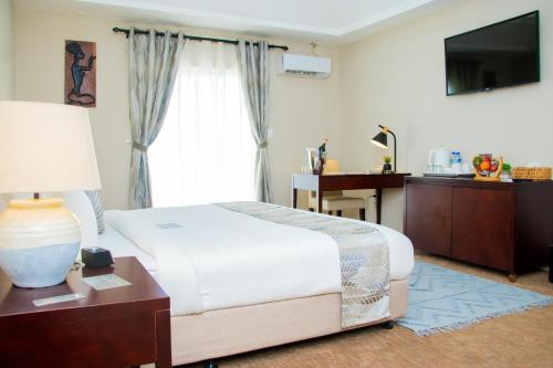 Royal Ambassador Hotel في Harbel: غرفة نوم بها سرير ونافذة كبيرة