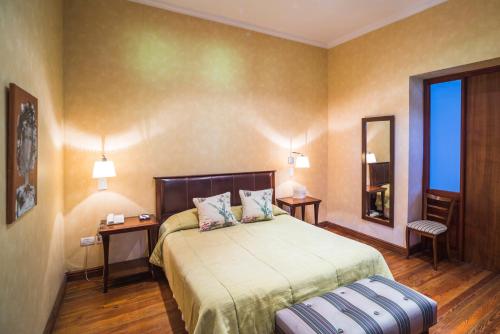 1 dormitorio con 1 cama, 2 mesas y espejo en Club Tapiz en Chacras de Coria