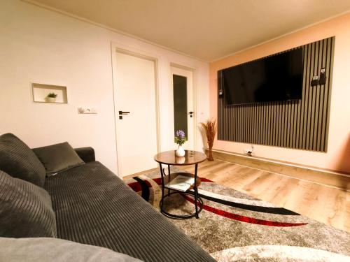 a living room with a couch and a television at Komfortabler Bungalow Am Schlosswald mit privater Sauna&Terrasse - Wernigerode Harz in Wernigerode