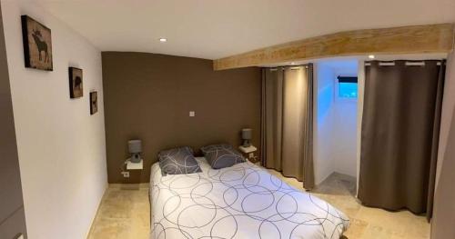 Appartement cosy au cœur de la Provence في جرافيزون: غرفة نوم بها سرير ووسادتين عليه