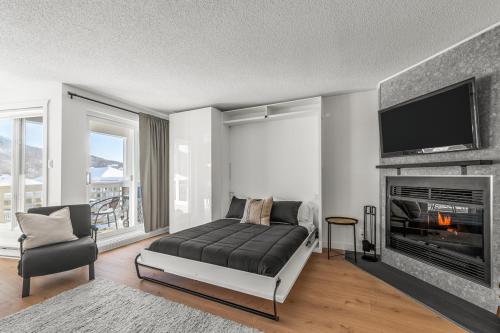 a bedroom with a bed and a fireplace at Hameau 26-43 Studio in Stoneham