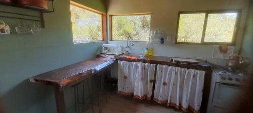 a kitchen with a wooden counter top and windows at Casa Iris del monte in La Pedrera