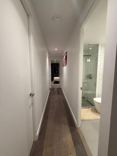 a hallway with a bathroom with a toilet and a sink at Cozy and Comfortable 2BR Apartment with master Ensuite and bathrooms in Melbourne