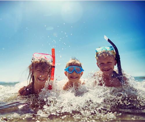 Três crianças estão deitadas na água com esquis. em Harmonia - Sunbeha resort, Juan Dolio em Juan Dolio