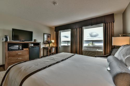 um quarto de hotel com uma cama e uma televisão em The View Hotel em Fort Saint James