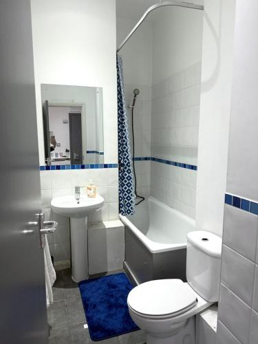a white bathroom with a toilet and a sink at Stylish City Loft Getaway in Nottingham