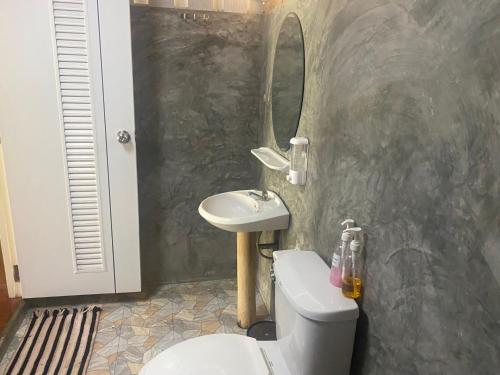 a bathroom with a sink and a toilet and a mirror at Mook Happy Bungalow in Koh Mook