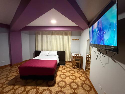 タクナにあるHostal Williamsのベッドと薄型テレビのある寝室