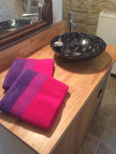 a bathroom counter with a pink towel and a sink at Maison de Charme dans la Cité in Sarlat-la-Canéda