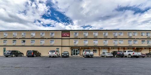 a large building with cars parked in a parking lot at The View Hotel in Fort Saint James