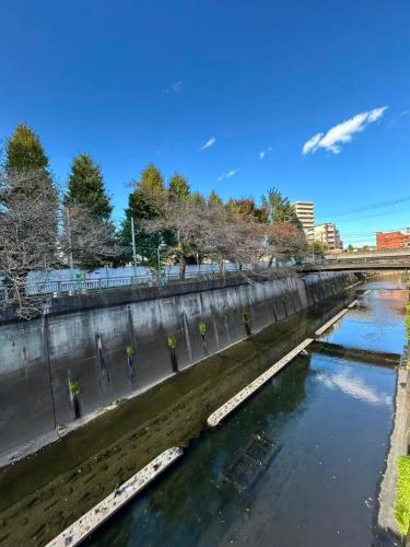 a bridge over a river with people walking on the sidewalk at Ikebukuro# Nakaitabashi 3DK room# 5 minutes walk from station in Tokyo