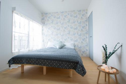 a bedroom with a bed with a blue blanket and a window at Ikebukuro# Nakaitabashi 3DK room# 5 minutes walk from station in Tokyo
