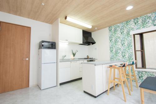 a kitchen with white cabinets and a wooden door at Ikebukuro# Nakaitabashi 3DK room# 5 minutes walk from station in Tokyo