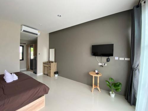 a bedroom with a bed and a flat screen tv at เขาค้อคริสตัลวิว,Khao kho Crystal View in Ban Huai Phai