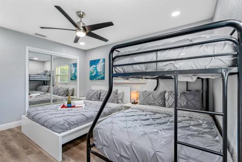 Un dormitorio con dos literas y un ventilador de techo. en Charming & Renovated Home 20 Minutes from Tampa, en Brandon