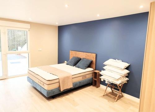 a blue bedroom with a bed and a chair at Domaine de la Brême 